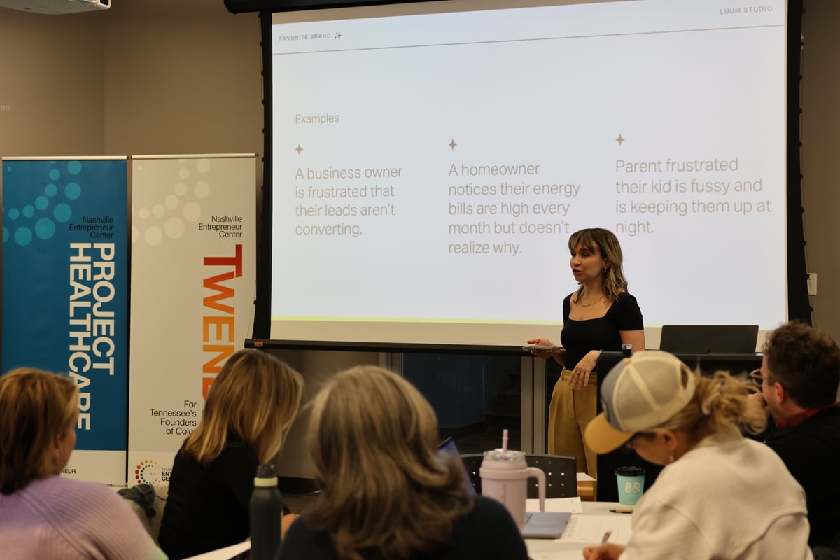 Presenter leading a workshop session on identifying customer pain points, with attendees seated at tables