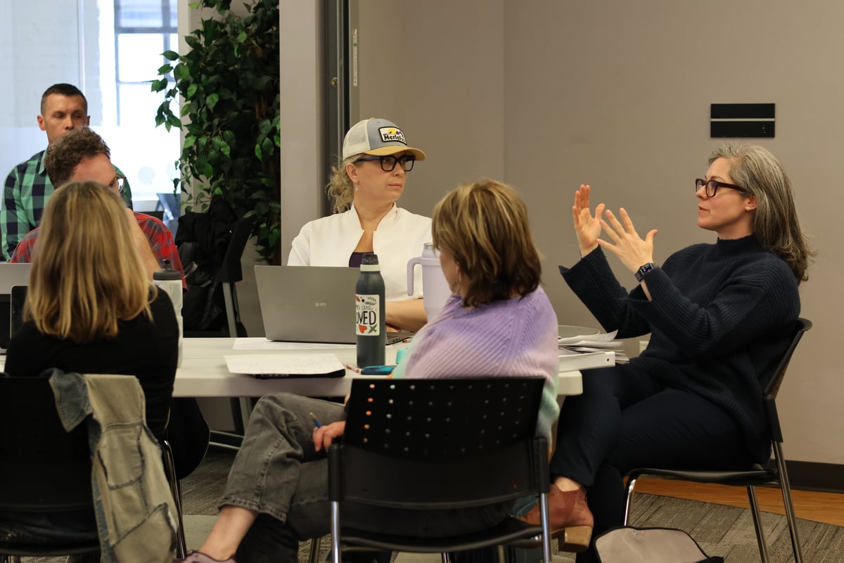 Founders in a small-group discussion around a table during a workshop session
