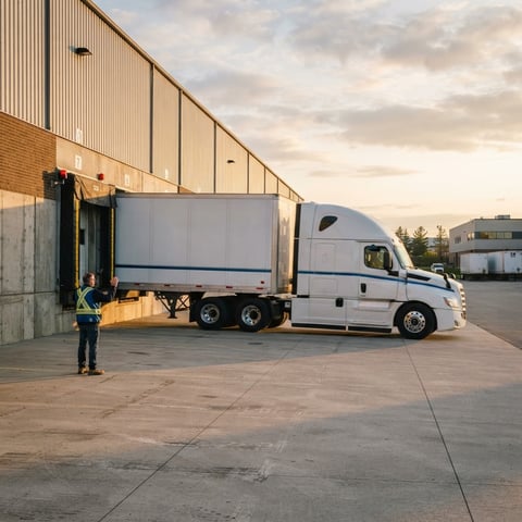 Semi truck backing into a warehouse loading bay